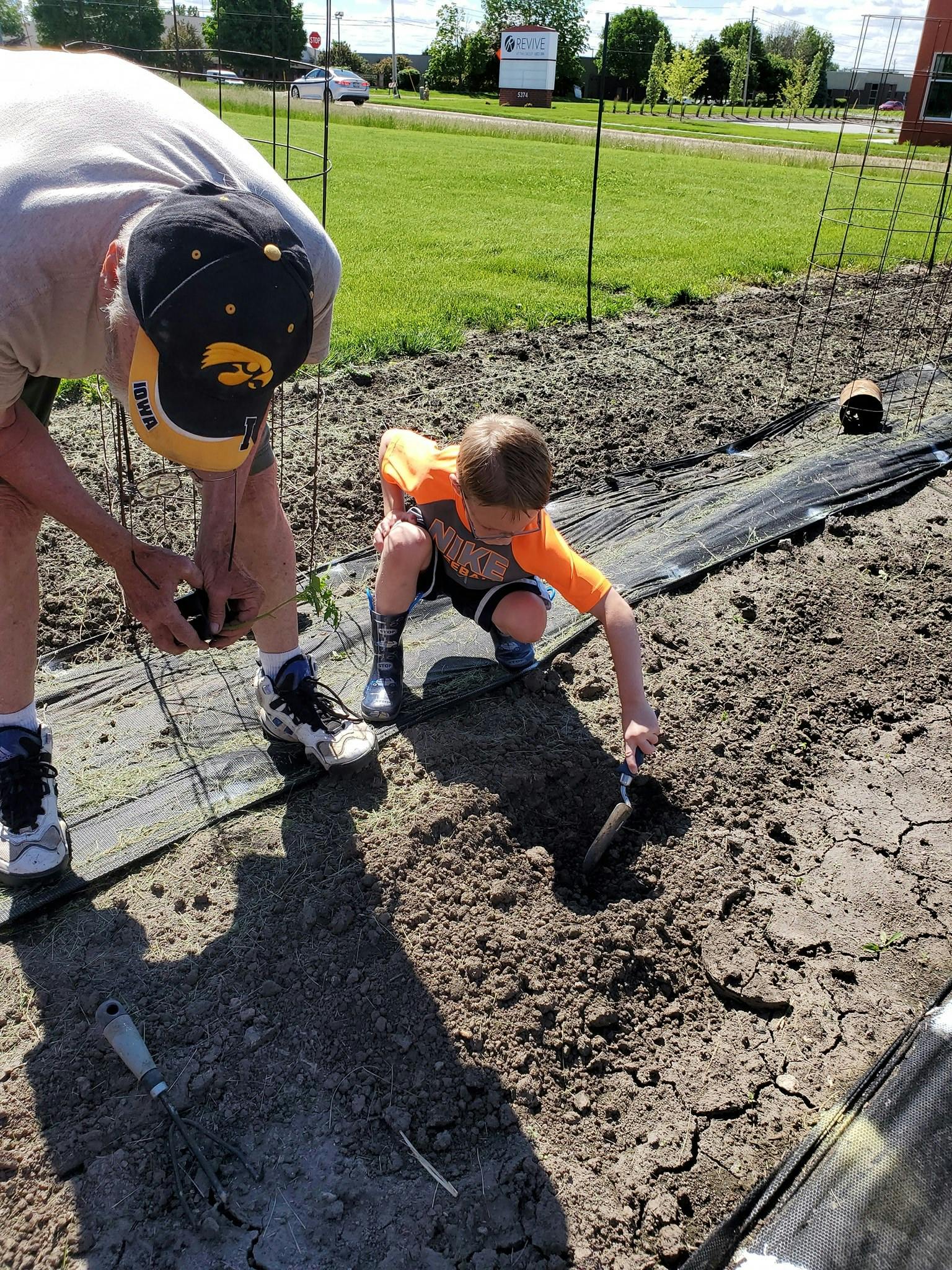 Person and child planting in a garden