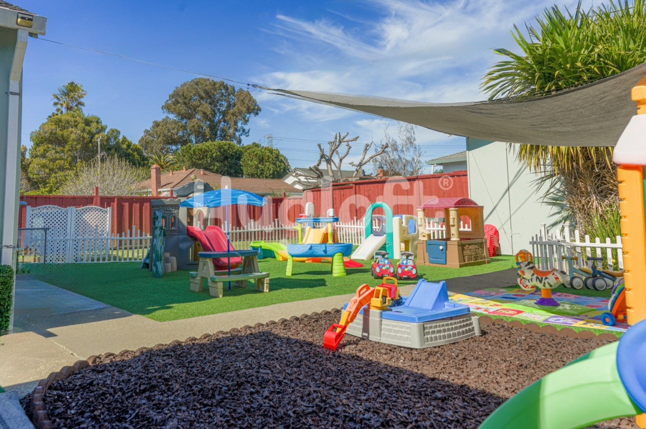 Outdoor playground with various play structures and a sandpit
