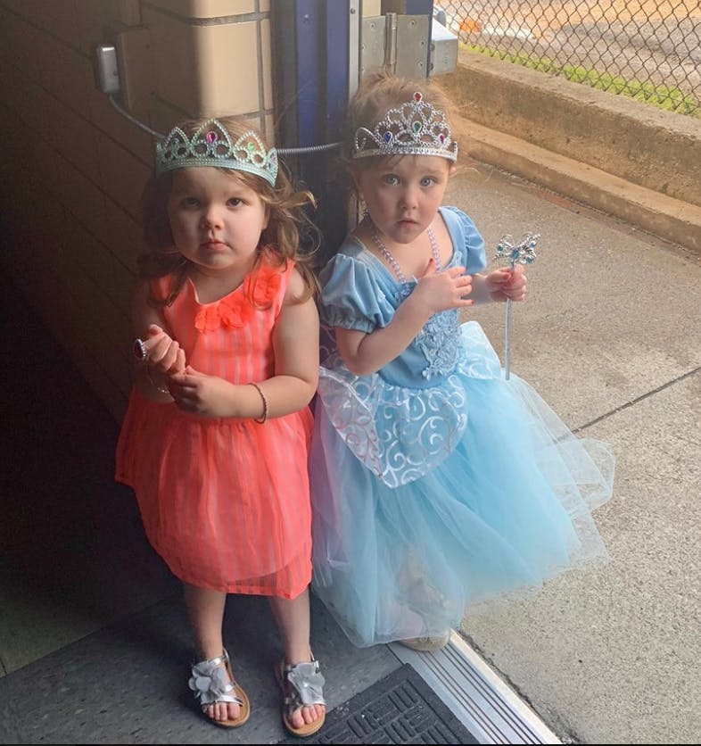 Two children wearing princess dresses and crowns