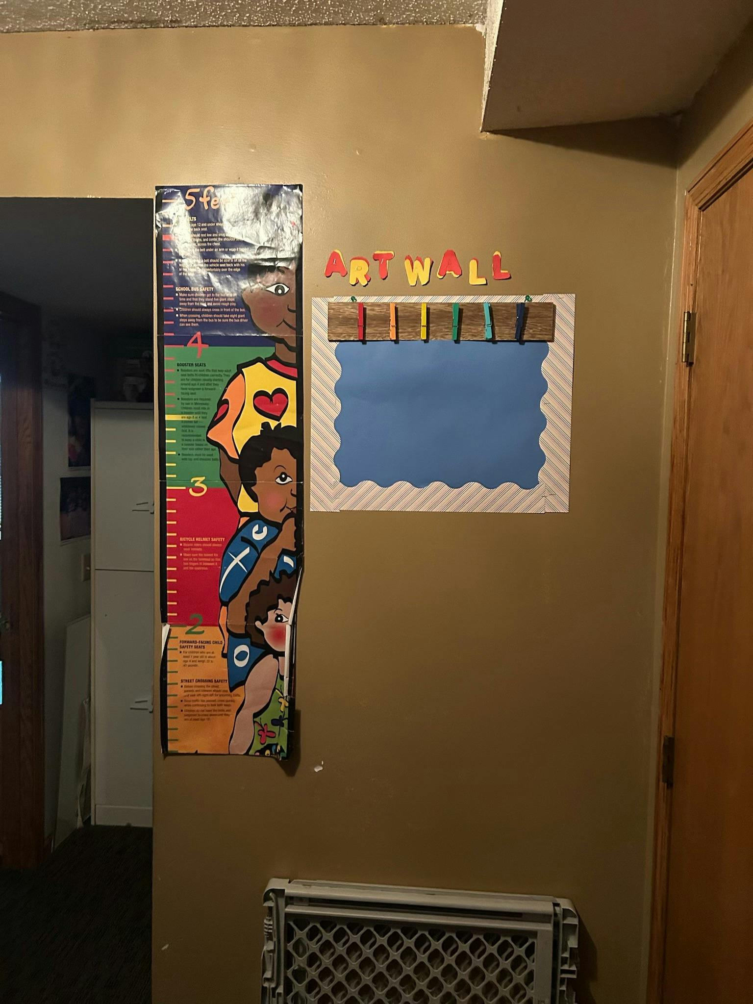 Growth chart with cartoon people next to an art wall display