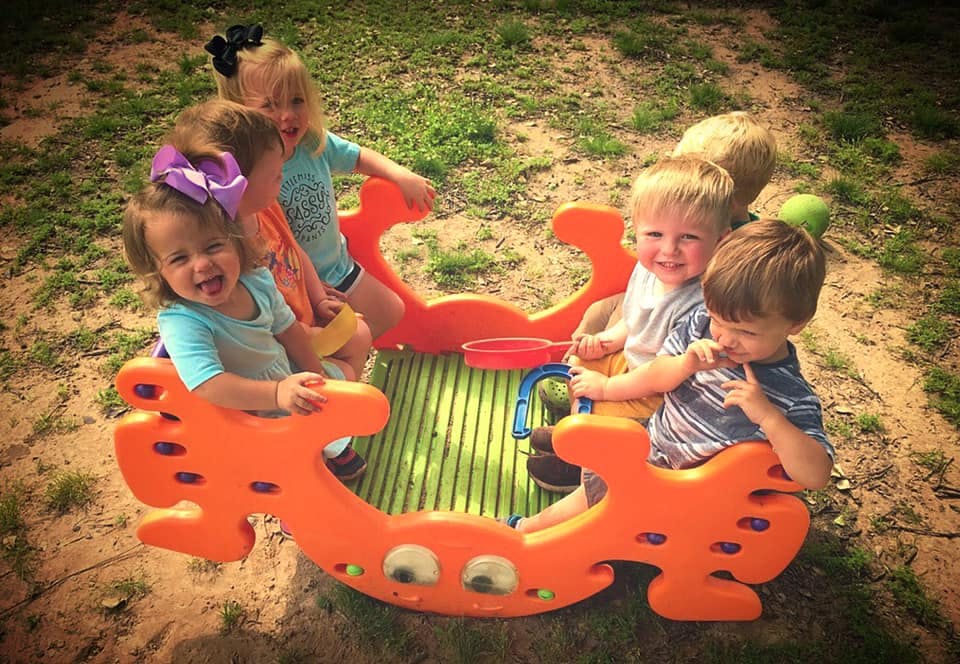 Children playing on a rocking toy outdoors