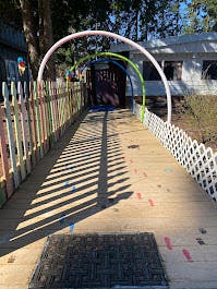 Wooden walkway with colorful fence and rainbow arch