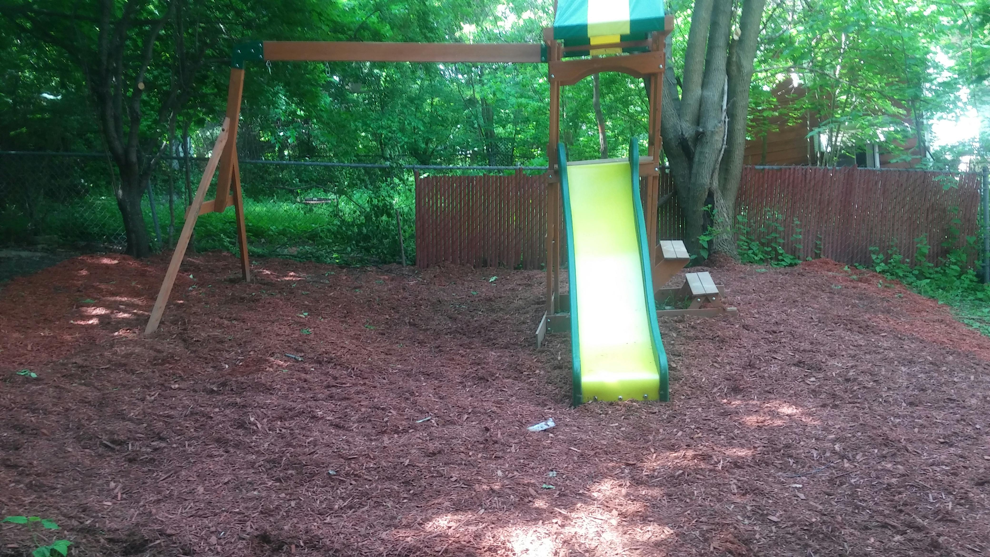 Swing set and slide in a backyard playground
