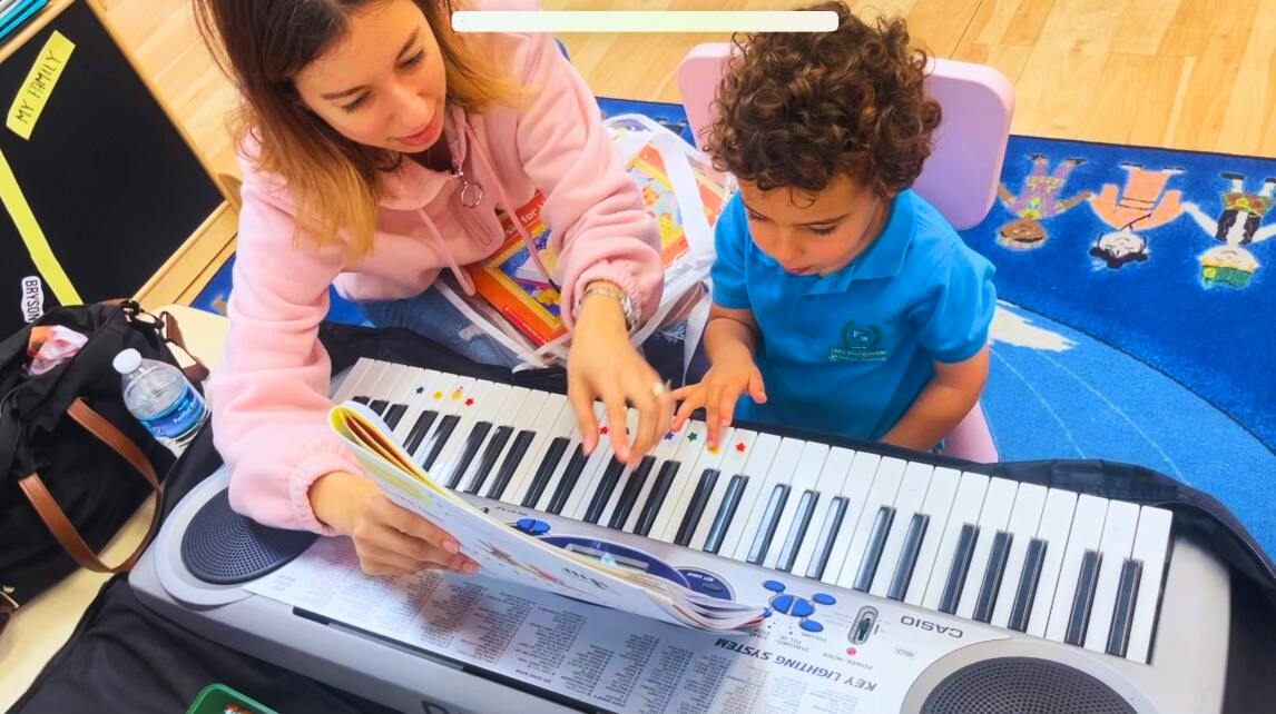 Person and child playing a keyboard