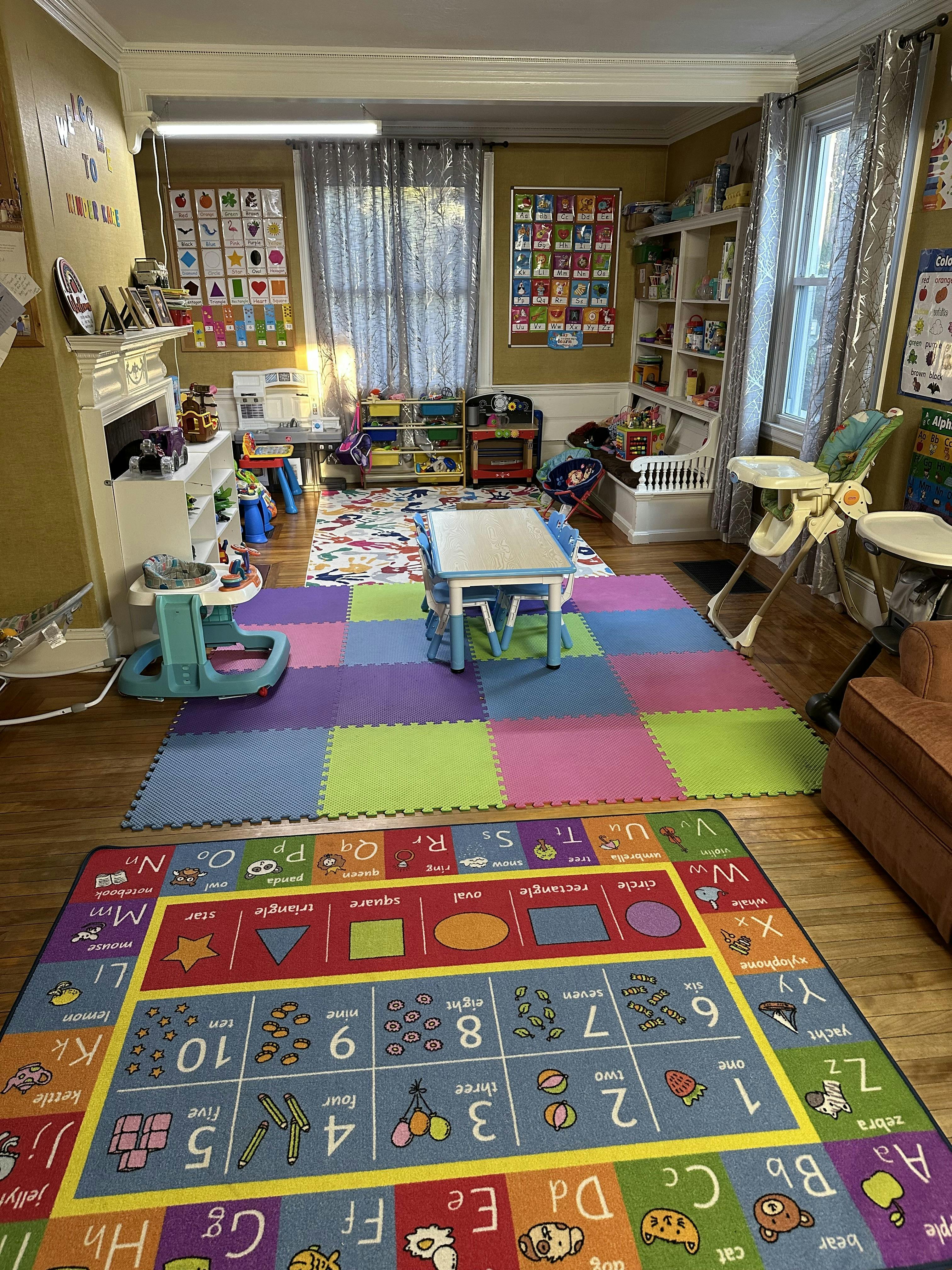 Playroom with colorful floor mats, small table and chairs, and toys
