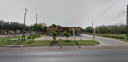 Building with a parking lot and road in front