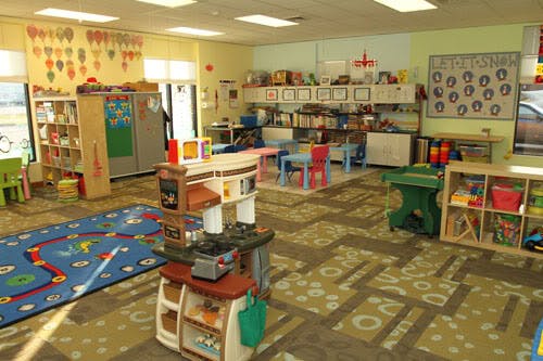 Playroom with toys, small tables, and chairs