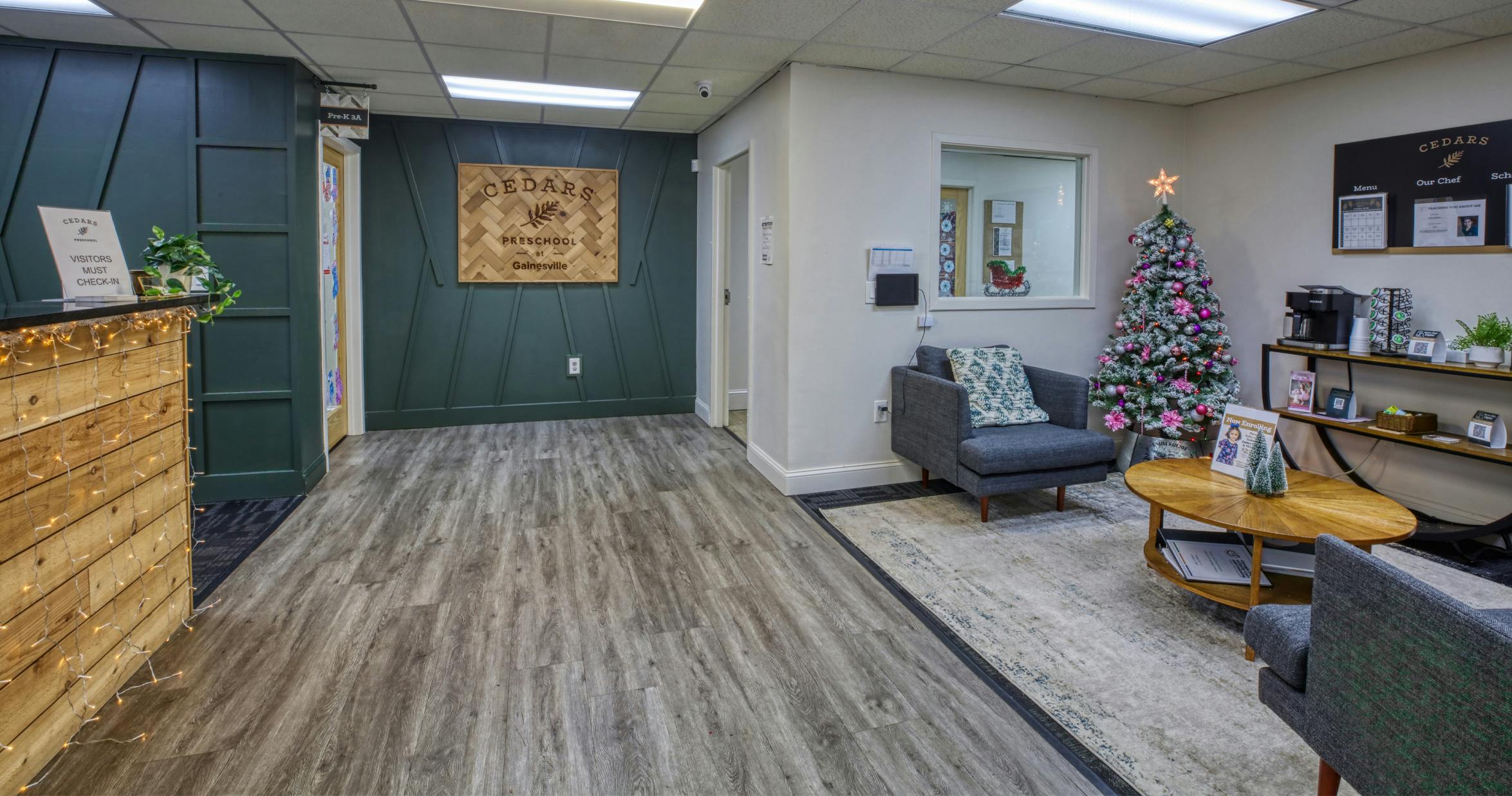 Lobby of a preschool with a check-in desk, Christmas tree, and seating area