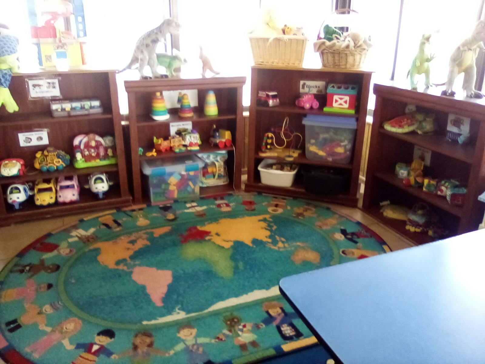 Playroom with a world map rug and shelves filled with toys