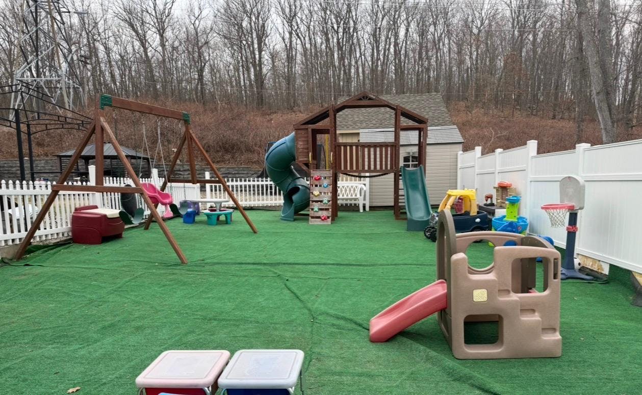 Backyard playground with wooden playset swings and various plastic slides