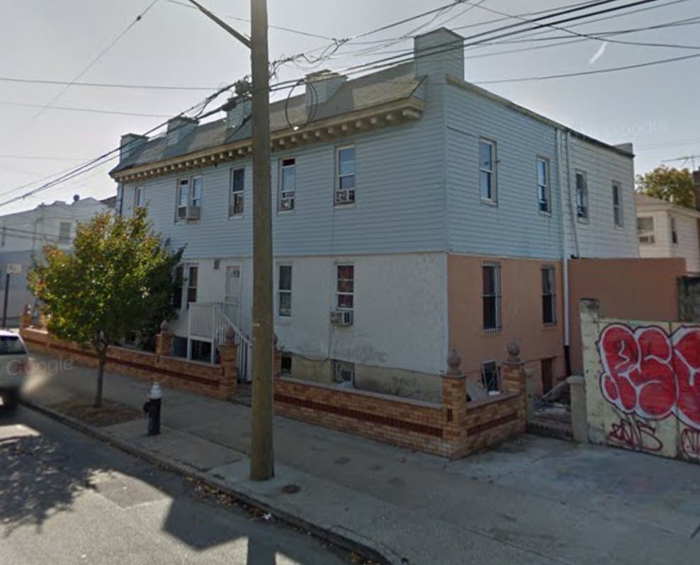 Two-story building with light blue siding and a brown lower level