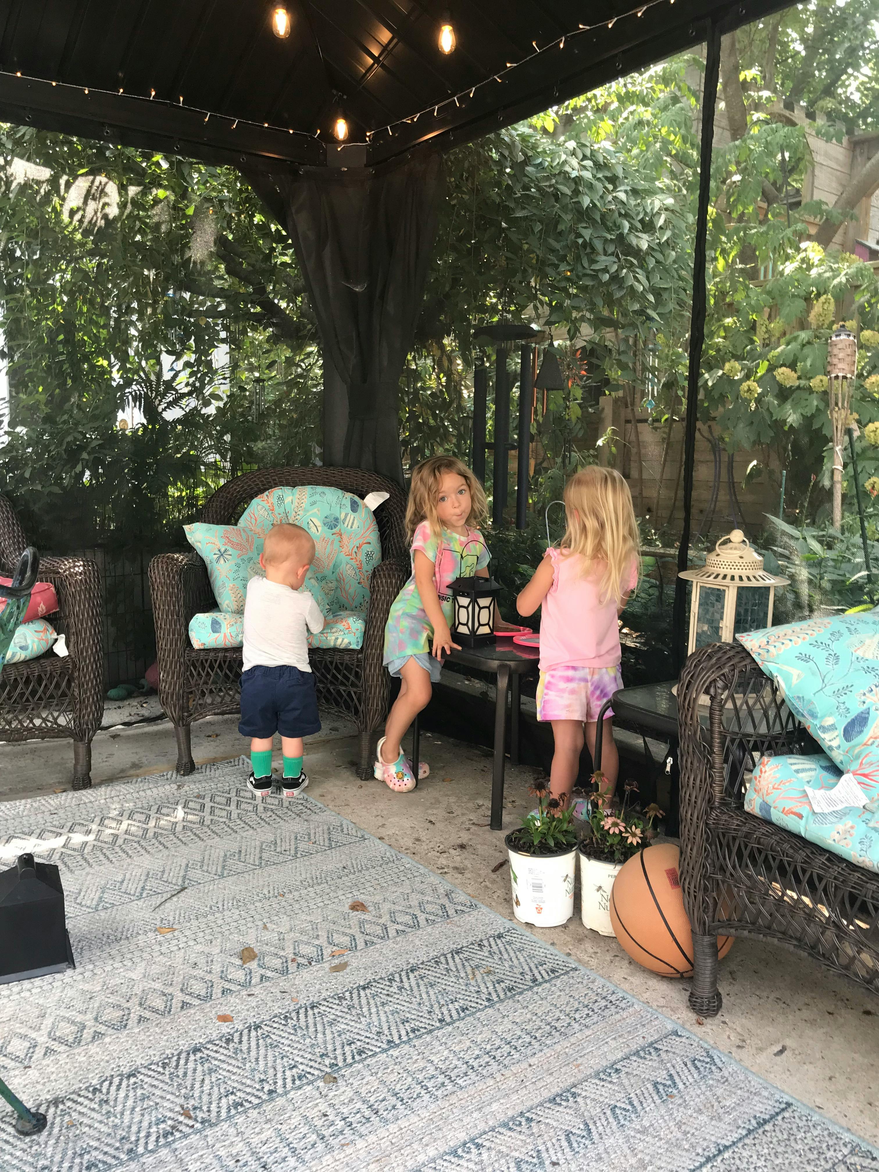 Three children playing on a patio
