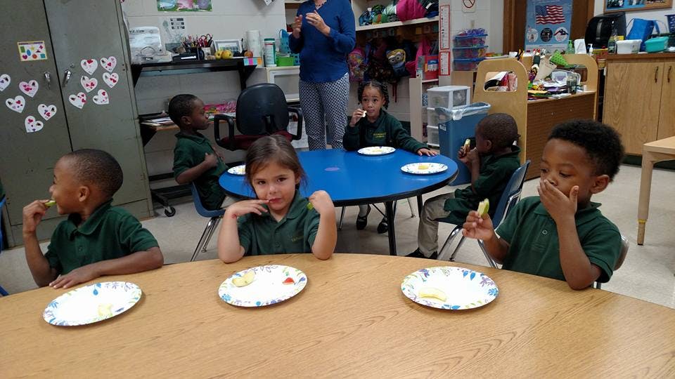 Children eating at tables in a classroom