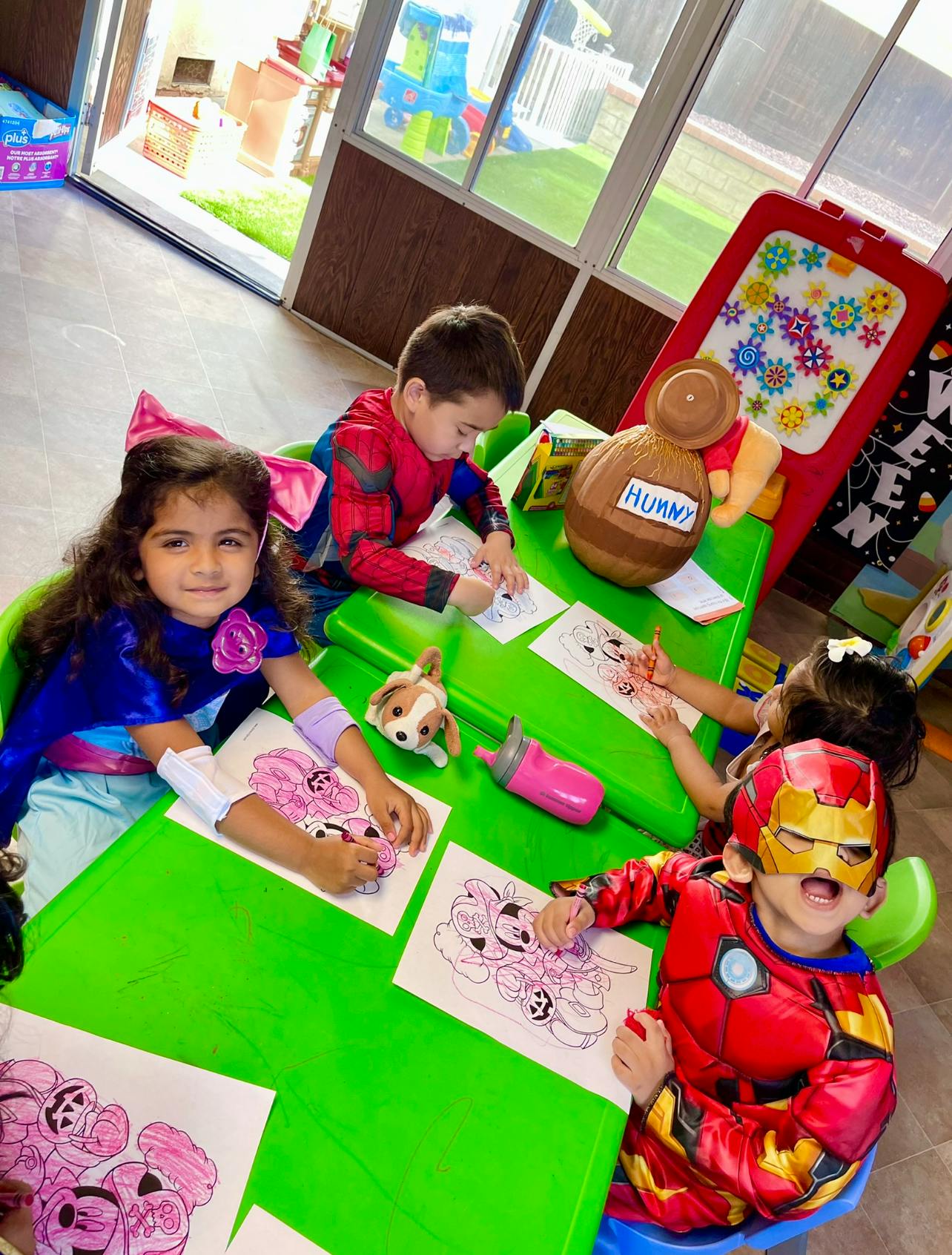 Children coloring at green tables