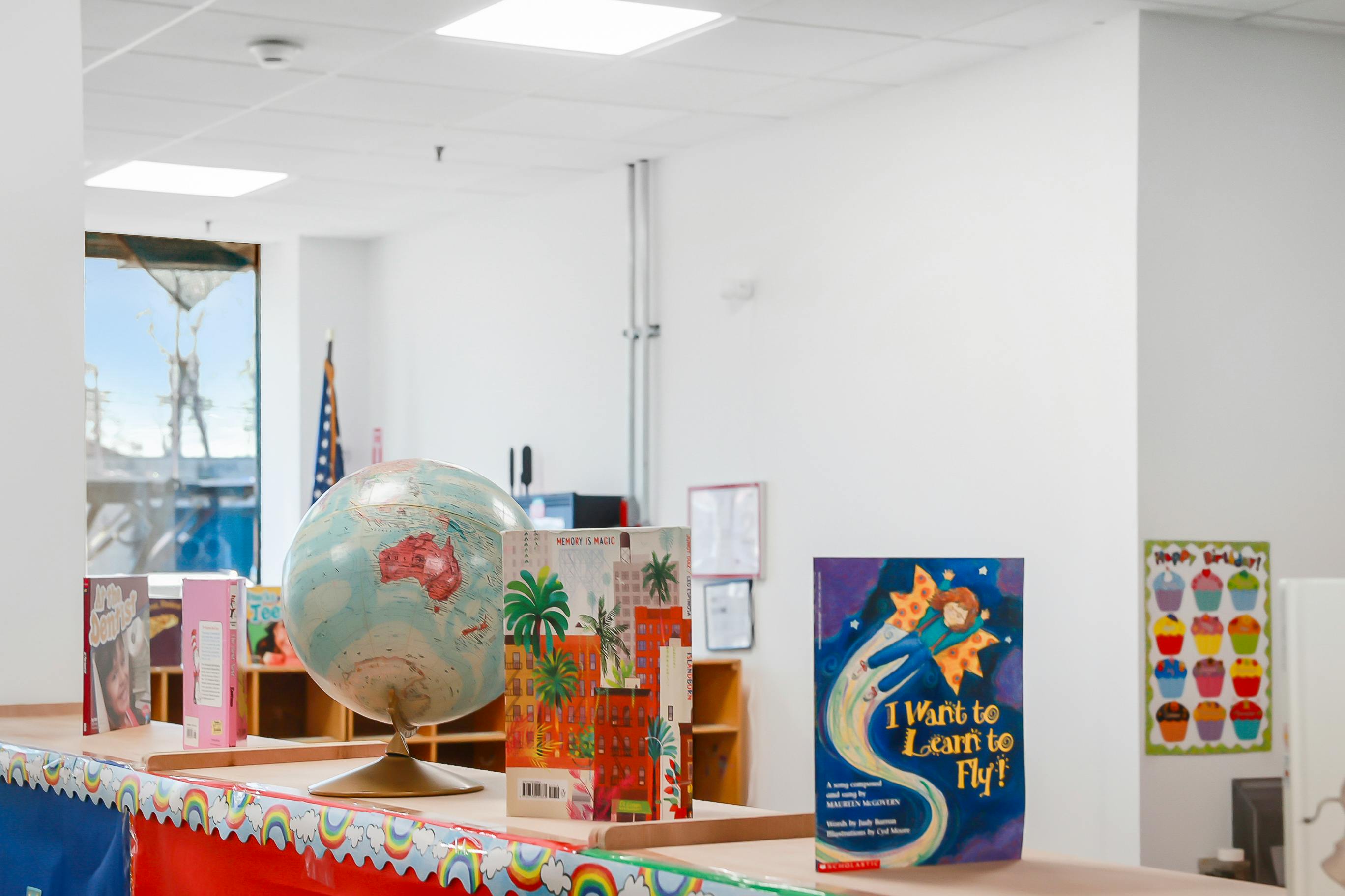 Globe and children books on a classroom shelf