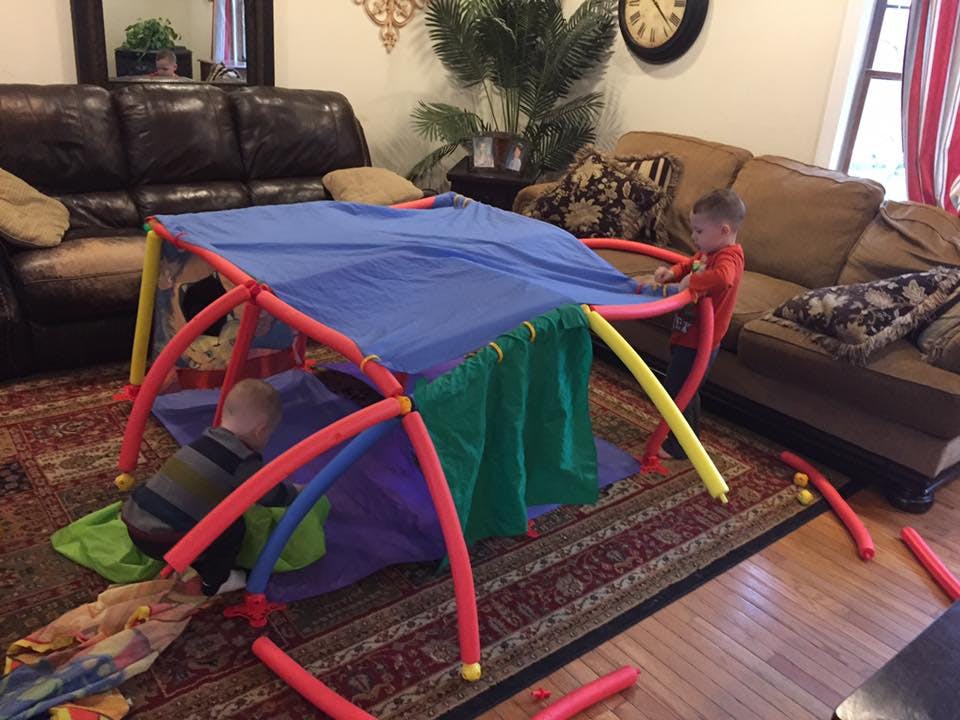 Child playing in a colorful indoor fort