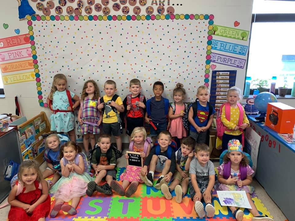 Group of children posing in a classroom