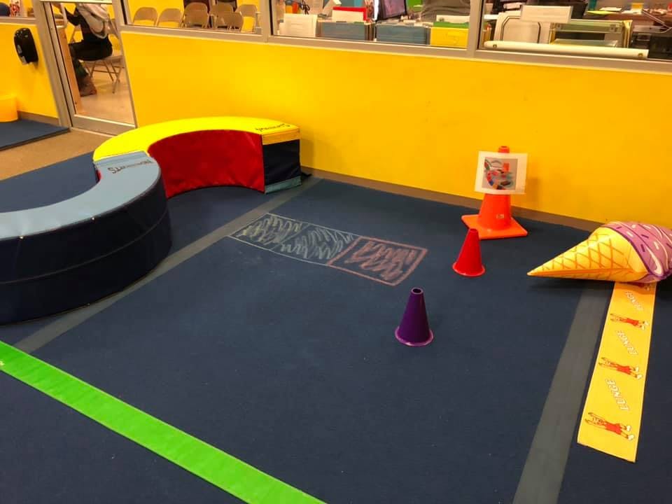 Playroom with floor cushions, traffic cones, and an ice cream cone prop