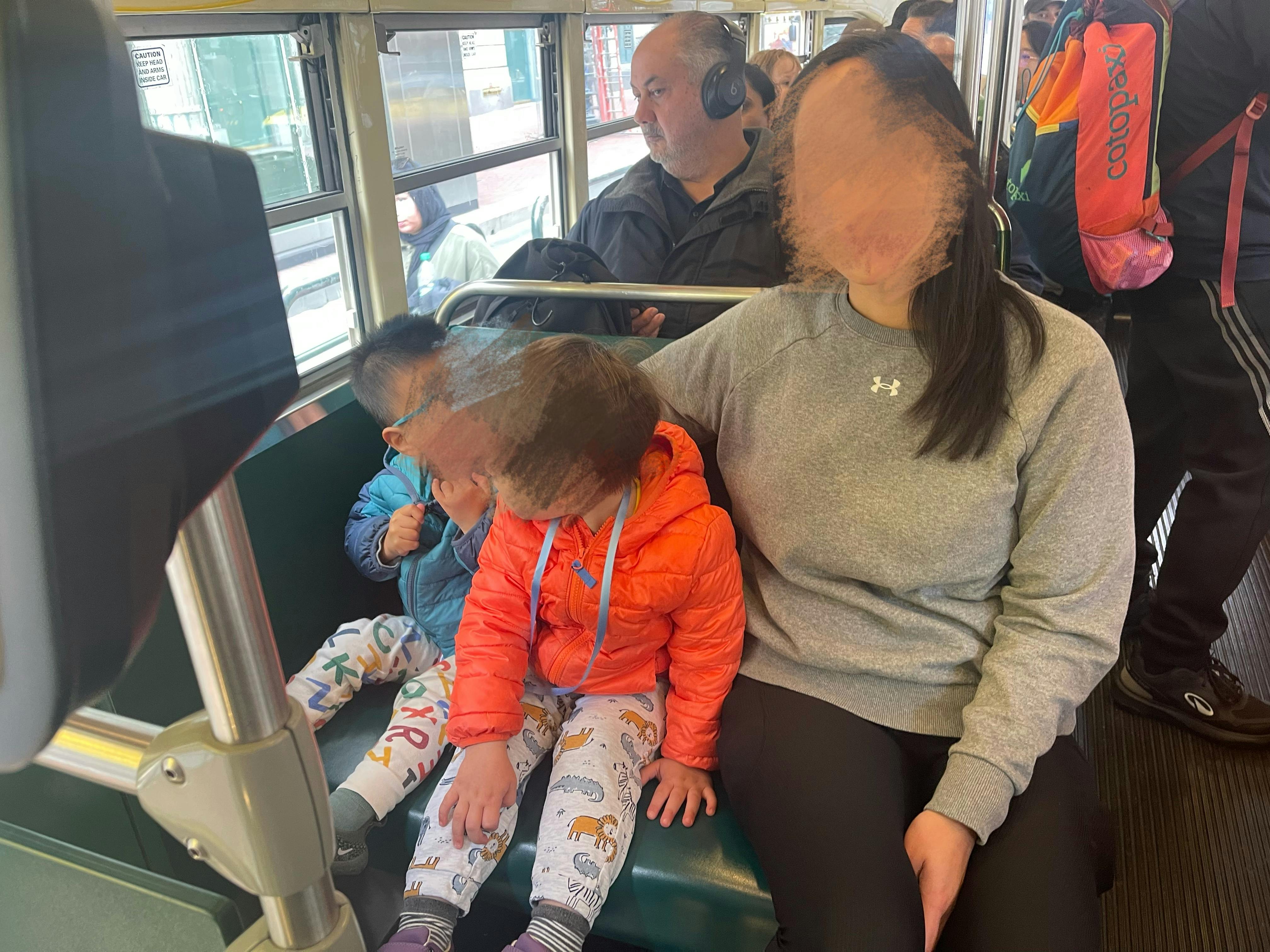 People sitting on a bus, including two children
