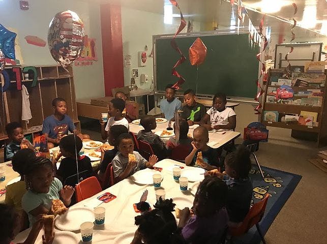 Children sitting at tables in a classroom