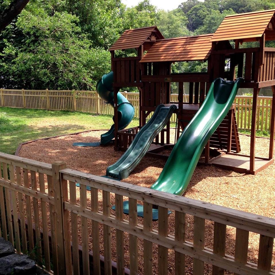 Wooden playground structure with multiple green slides
