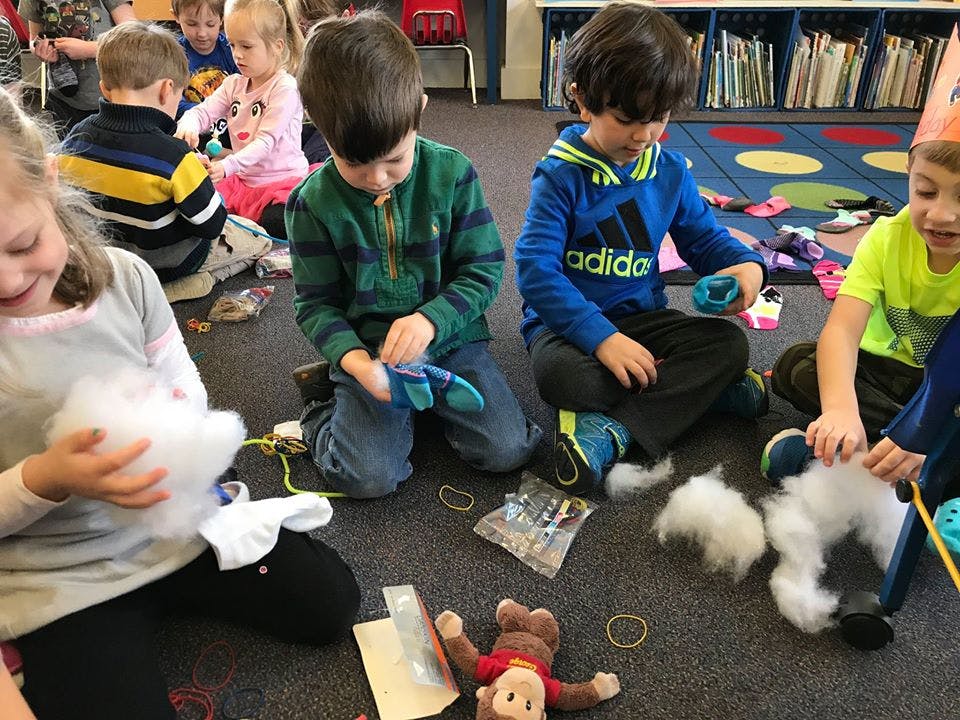 Children sitting on floor, working with craft supplies