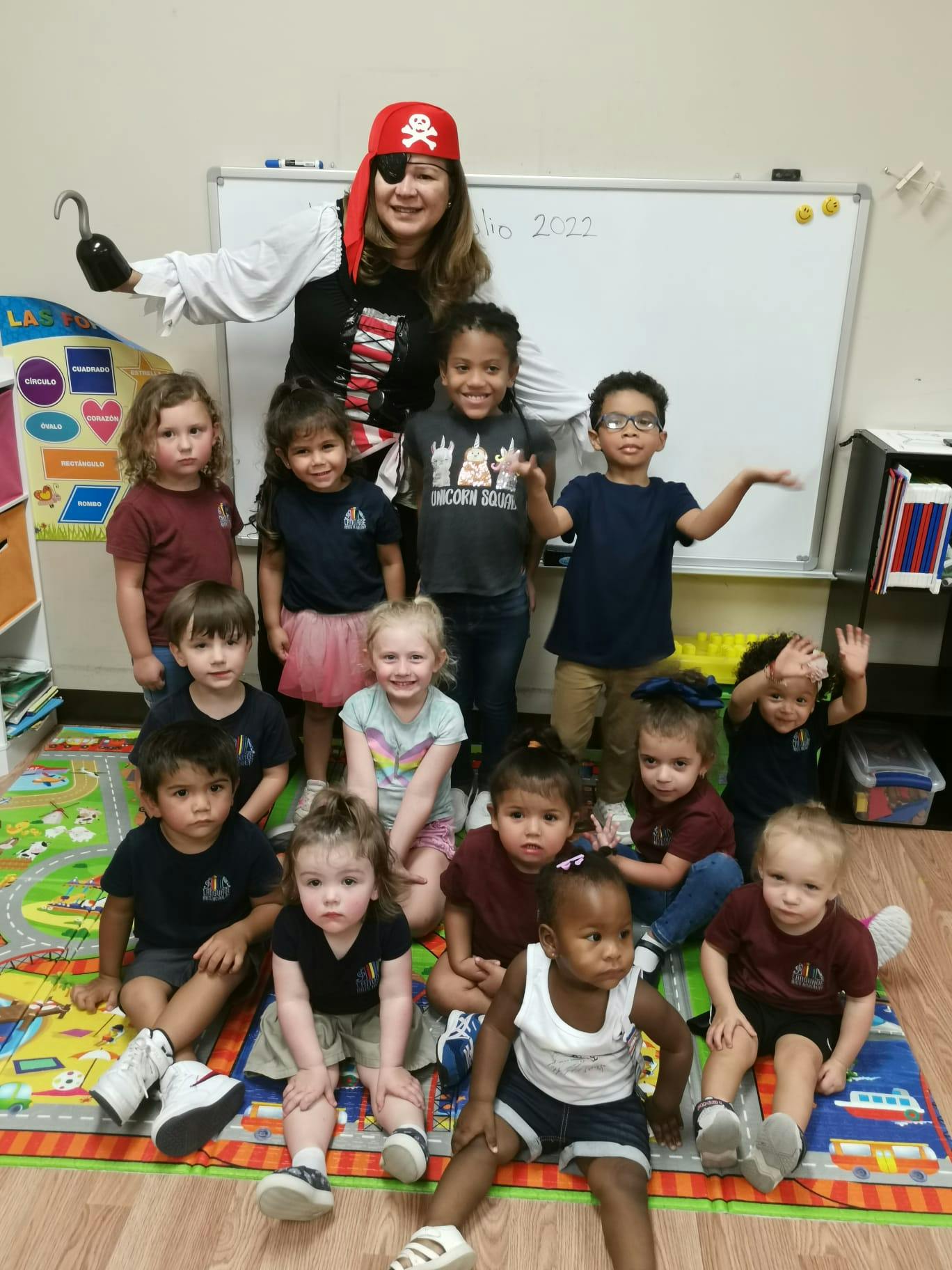 Person in pirate costume with a group of children in a classroom