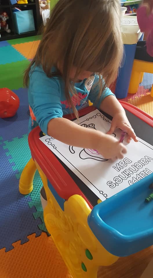 Child coloring a Happy Valentine's Day picture