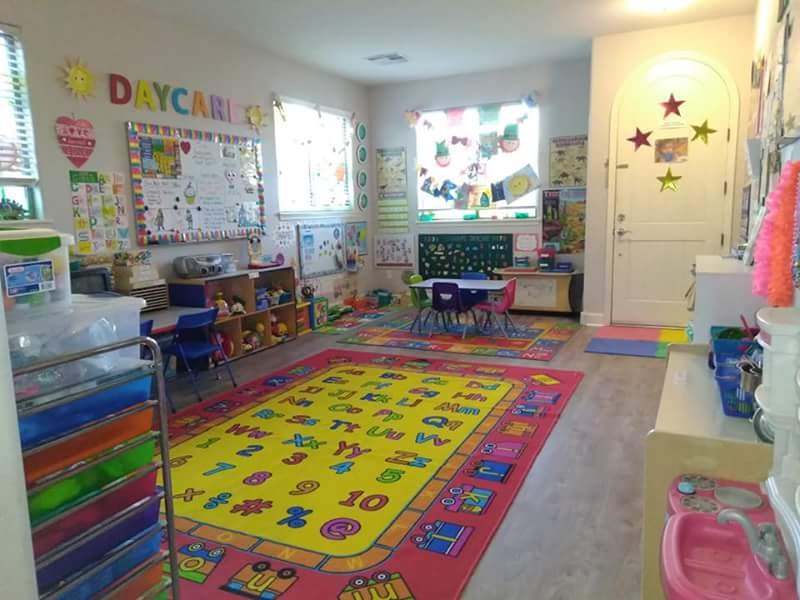 Colorful daycare room with alphabet rug and small tables