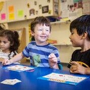 Three children sitting at a table in a classroom
