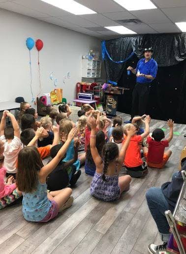 Person performing for children with raised hands