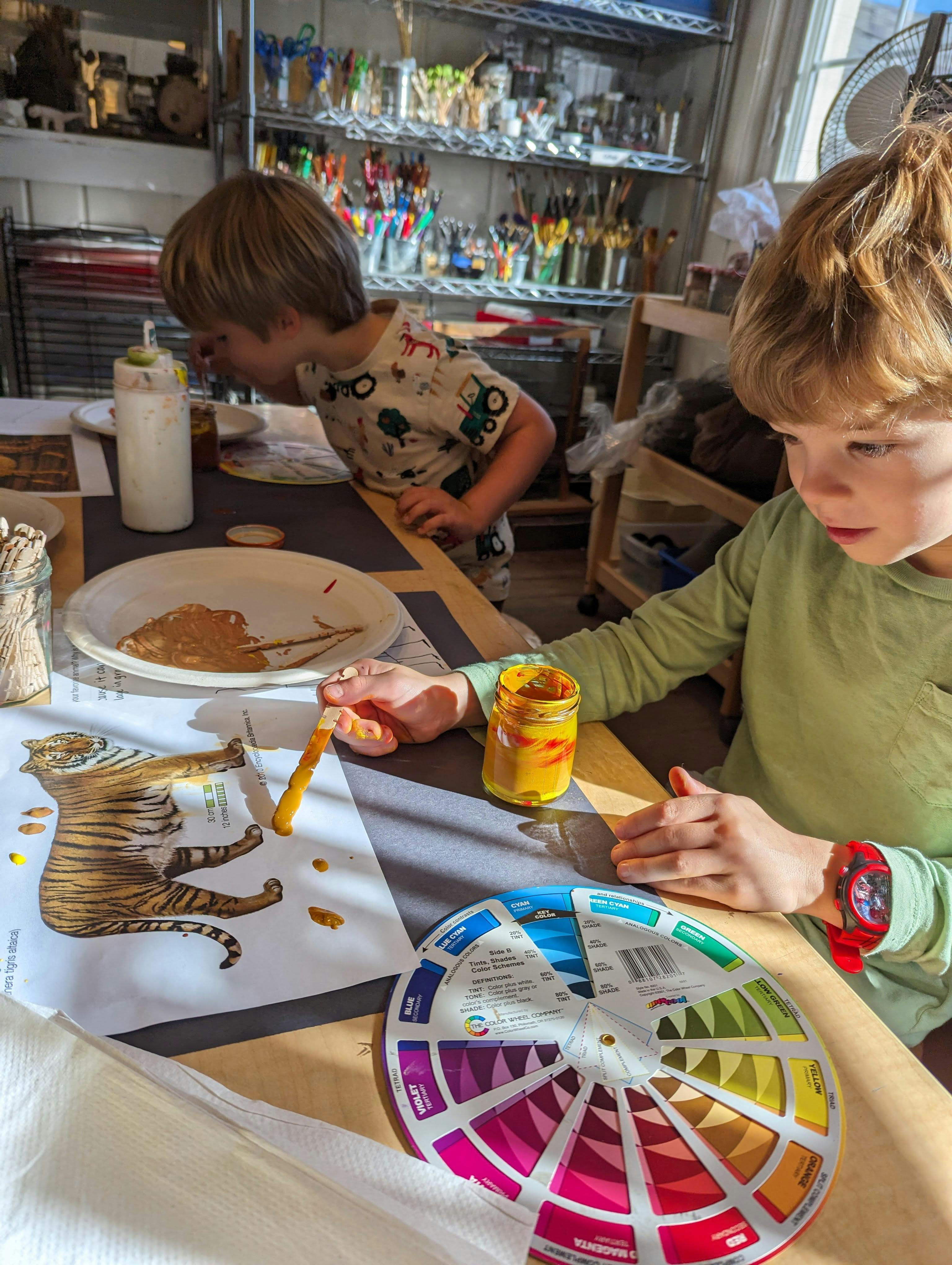 Two children painting a tiger drawing