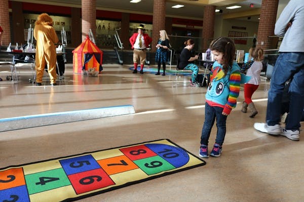 Child standing near a hopscotch mat indoors