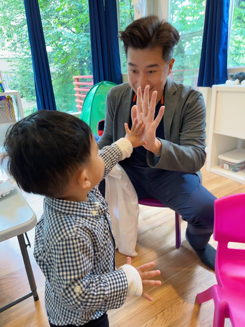 Adult and child playing patty cake