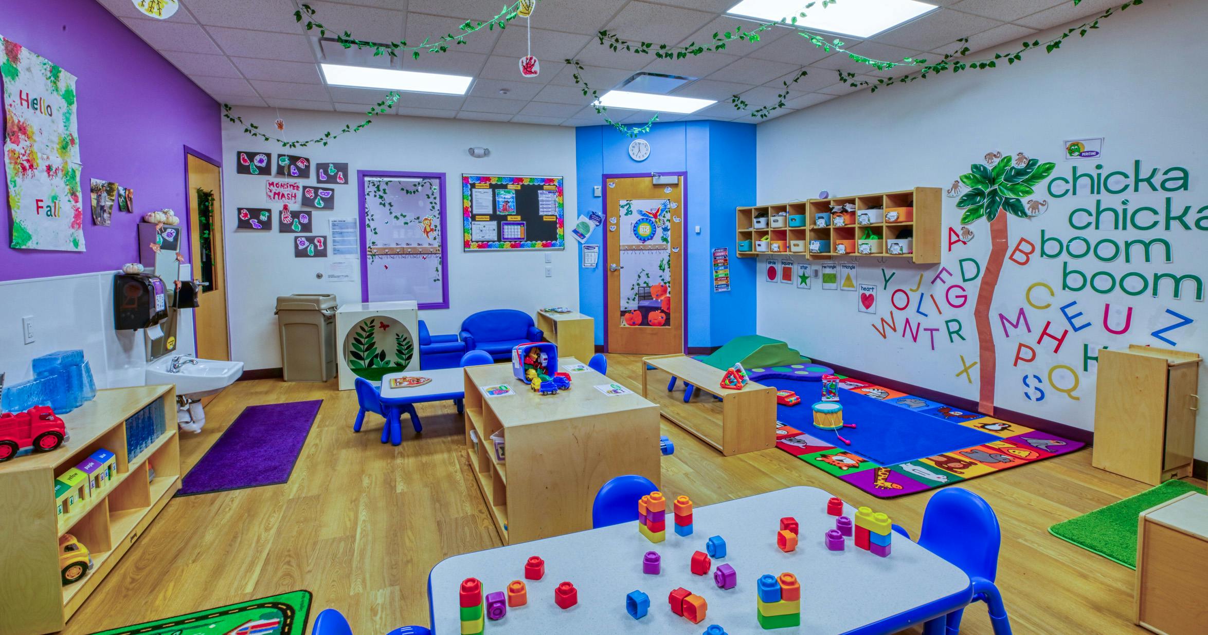 Colorful classroom with child-sized tables, chairs, and learning decorations