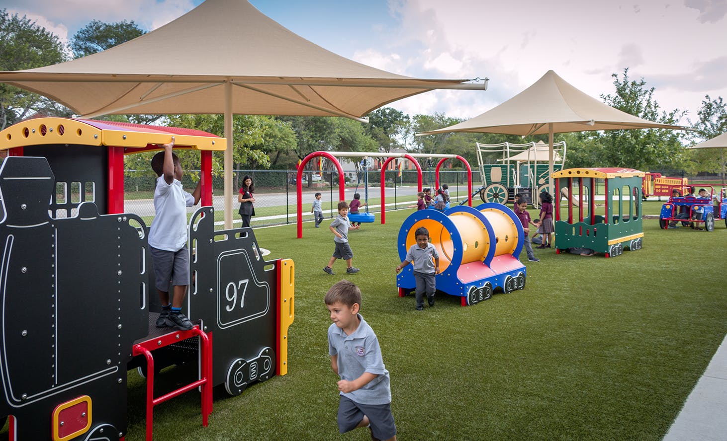 Children playing on a playground with train-themed equipment