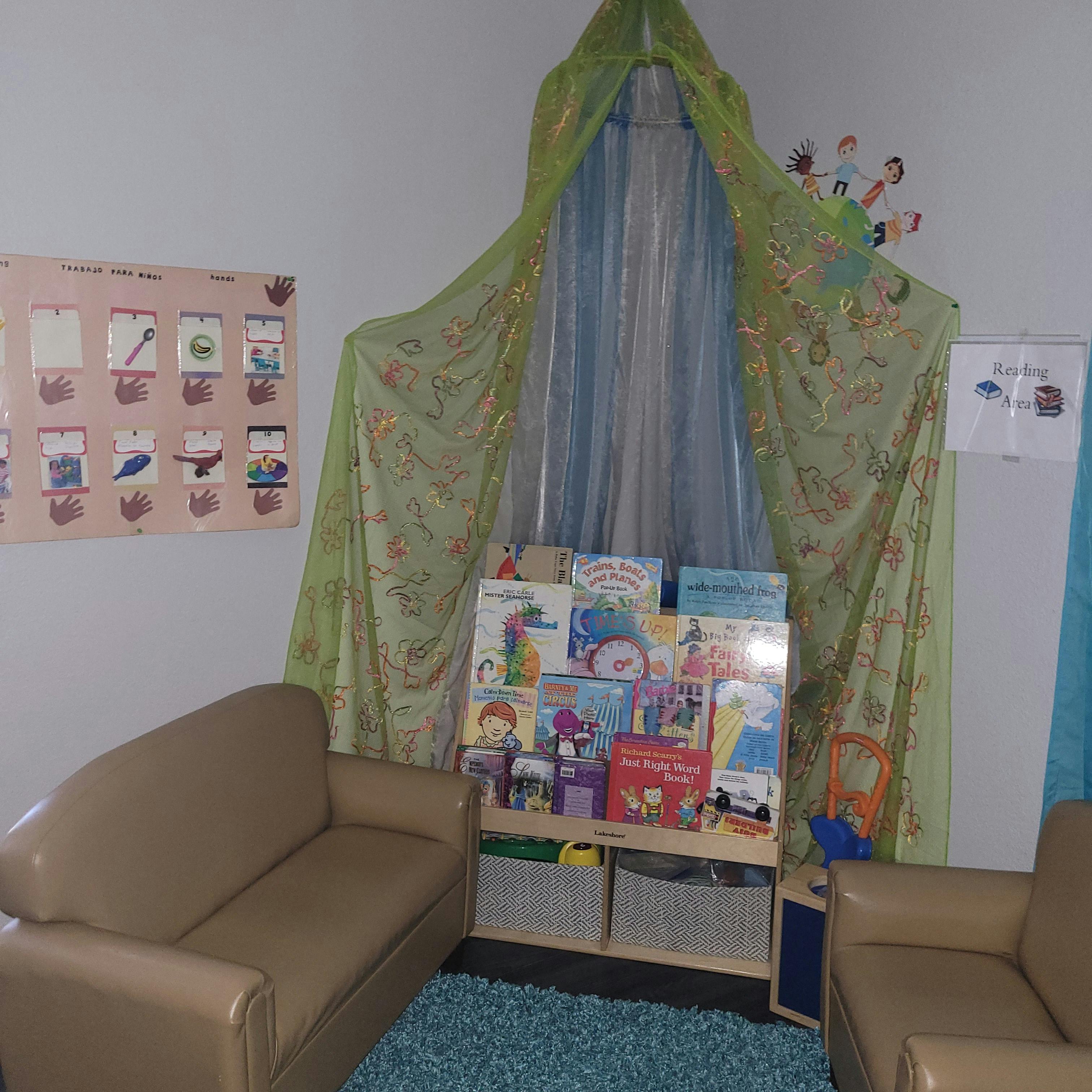 Reading nook with small couches, a bookshelf, and a canopy