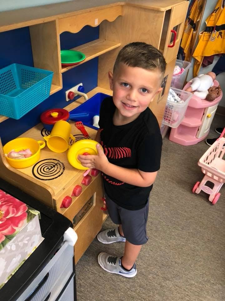 Child playing with a toy kitchen set