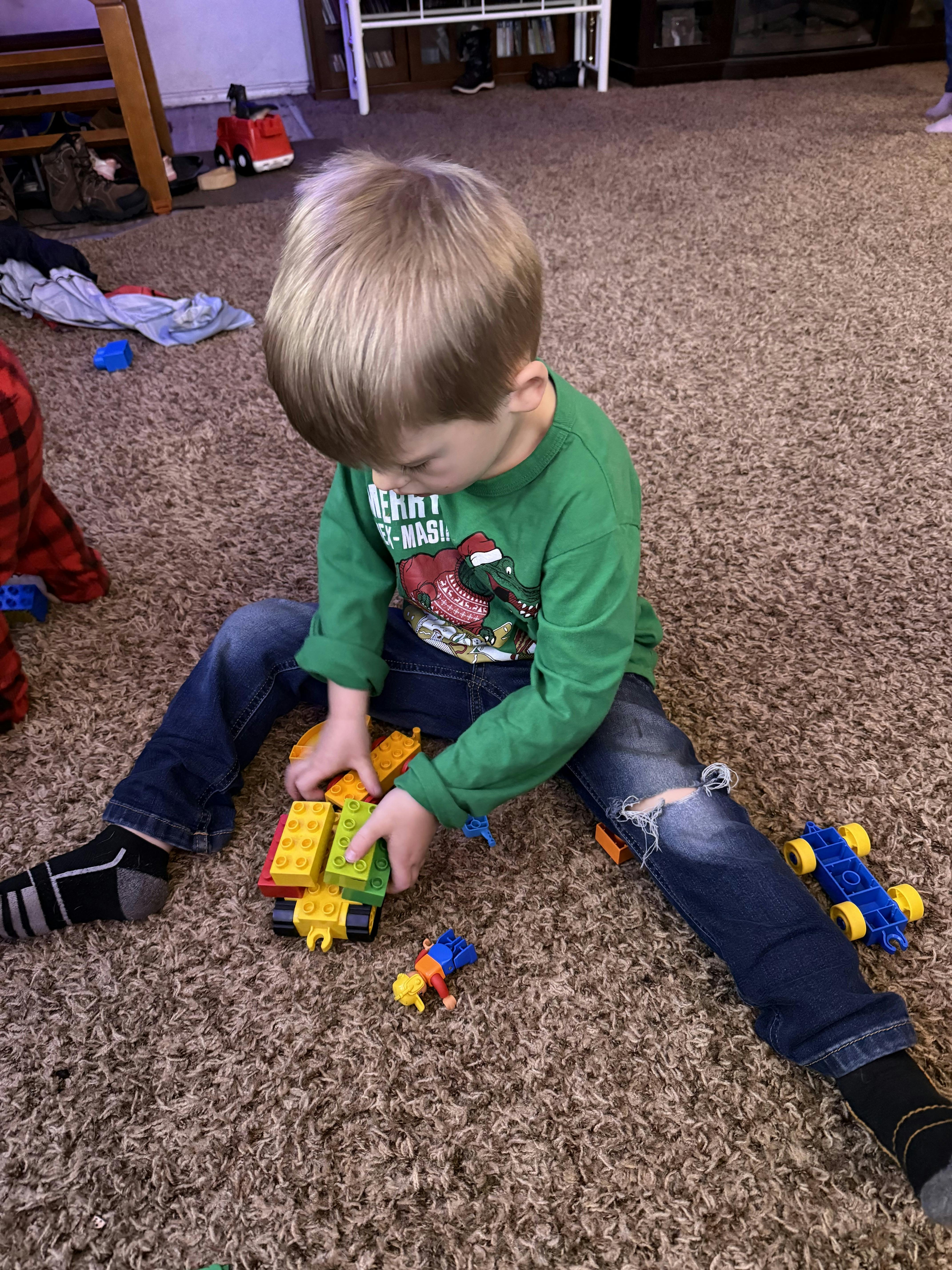 Child sitting on carpet playing with building blocks