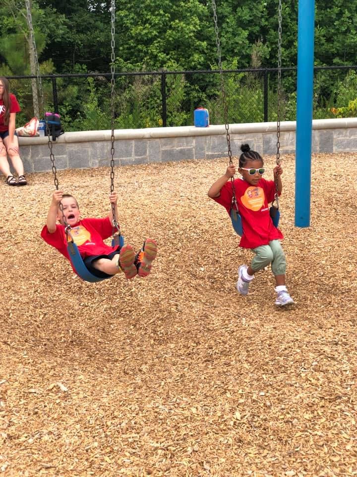 Two children on swings at a playground