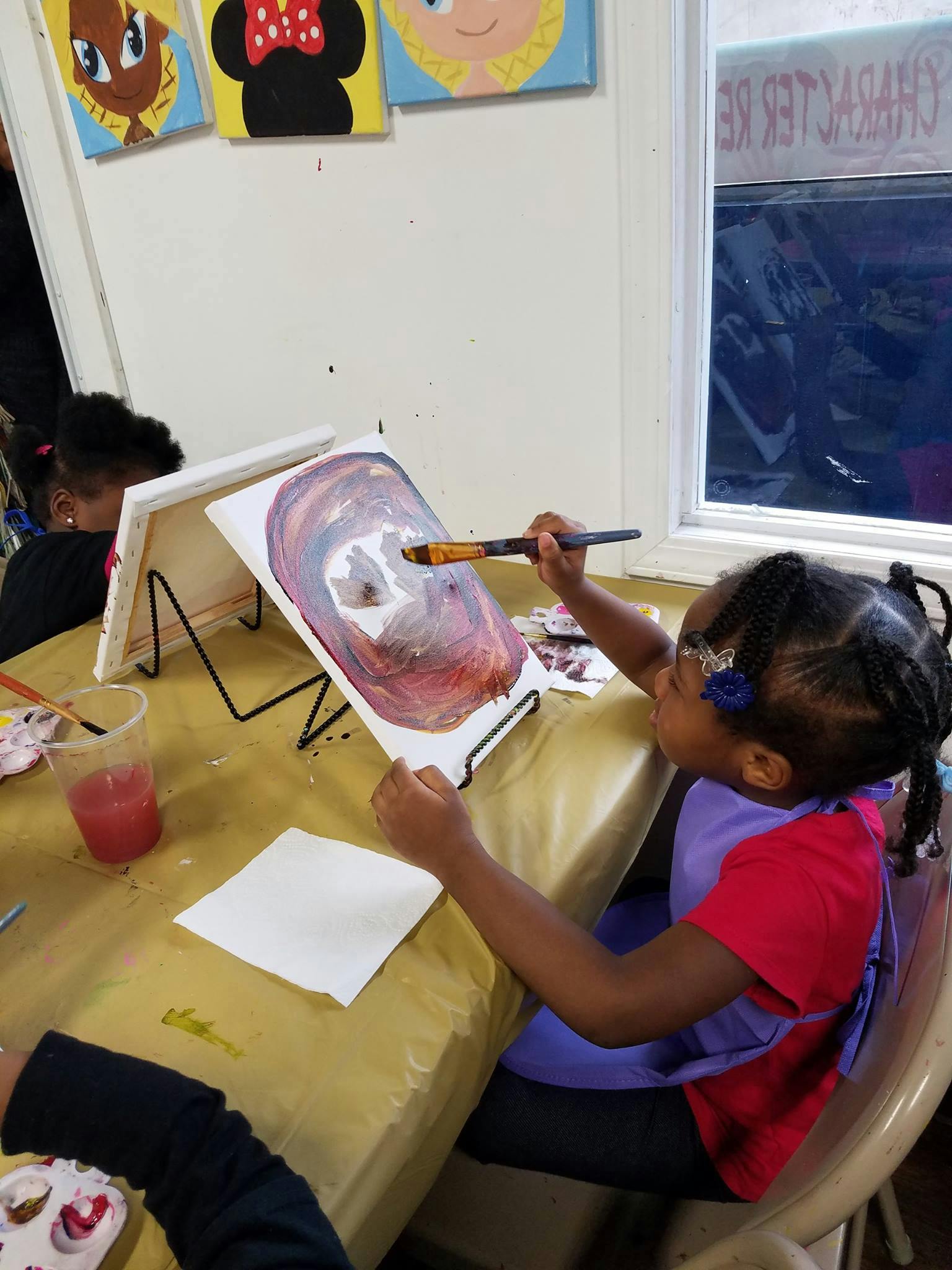 Child painting on an easel at a table