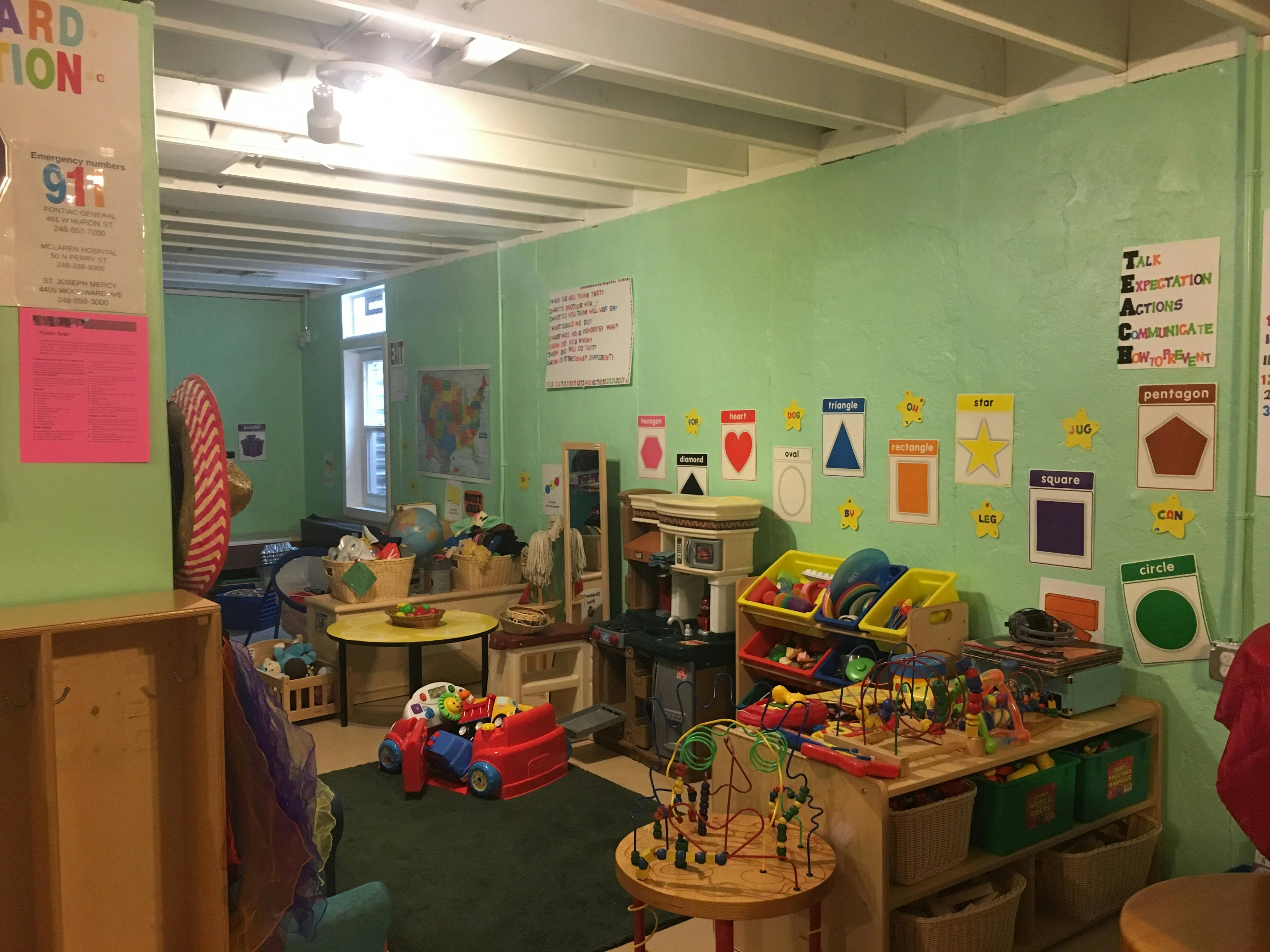 Playroom with toys, tables, and shapes on the wall