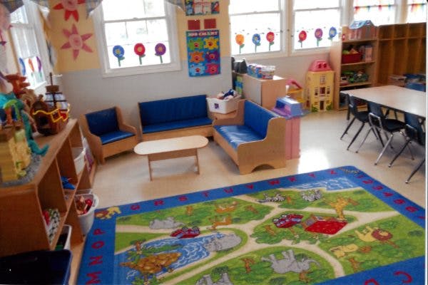 Classroom with blue couches, small table, and colorful rug