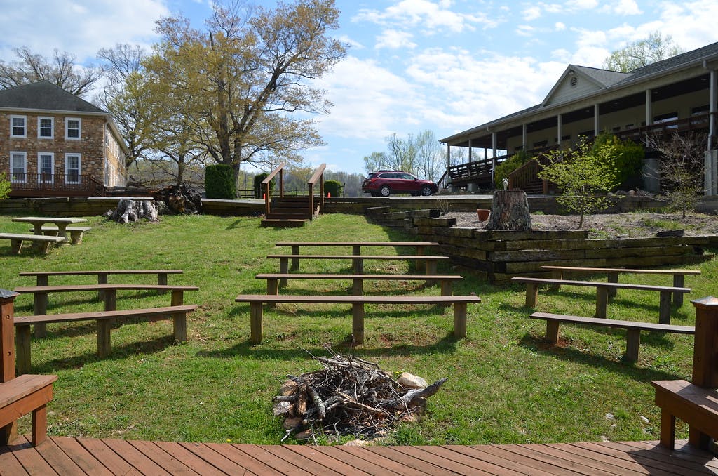 Outdoor seating area with wooden benches and a pile of logs for a bonfire