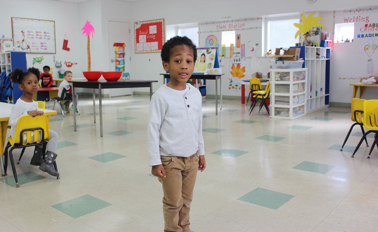 Child standing in a classroom