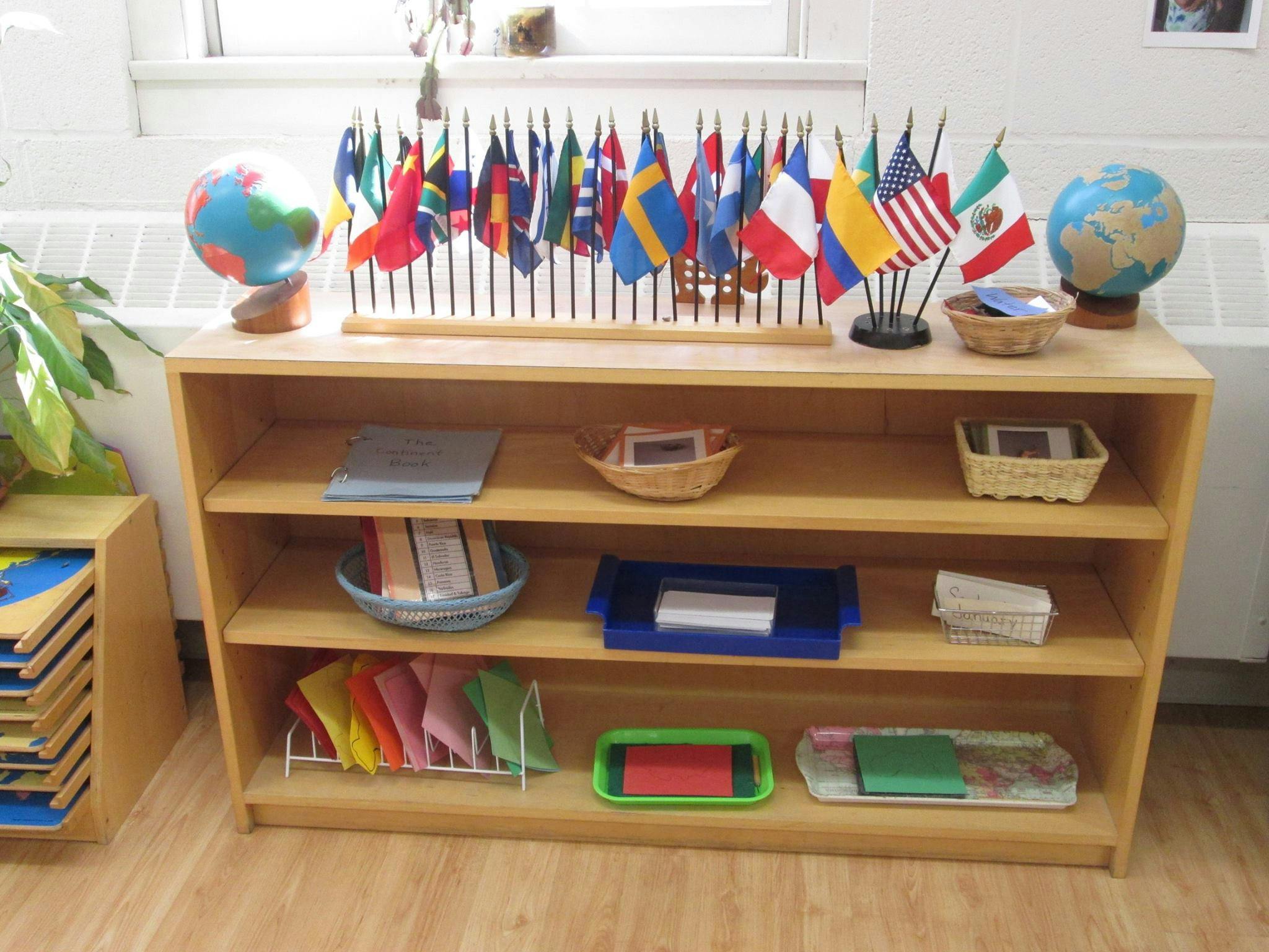 Shelf with globes, flags, and learning materials