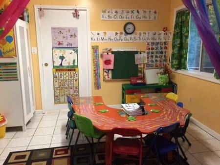 Classroom with a U-shaped table and chairs, alphabet charts on the wall