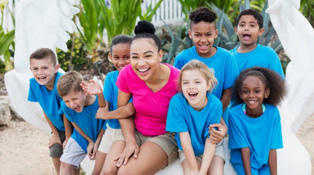 Adult and group of children in blue shirts
