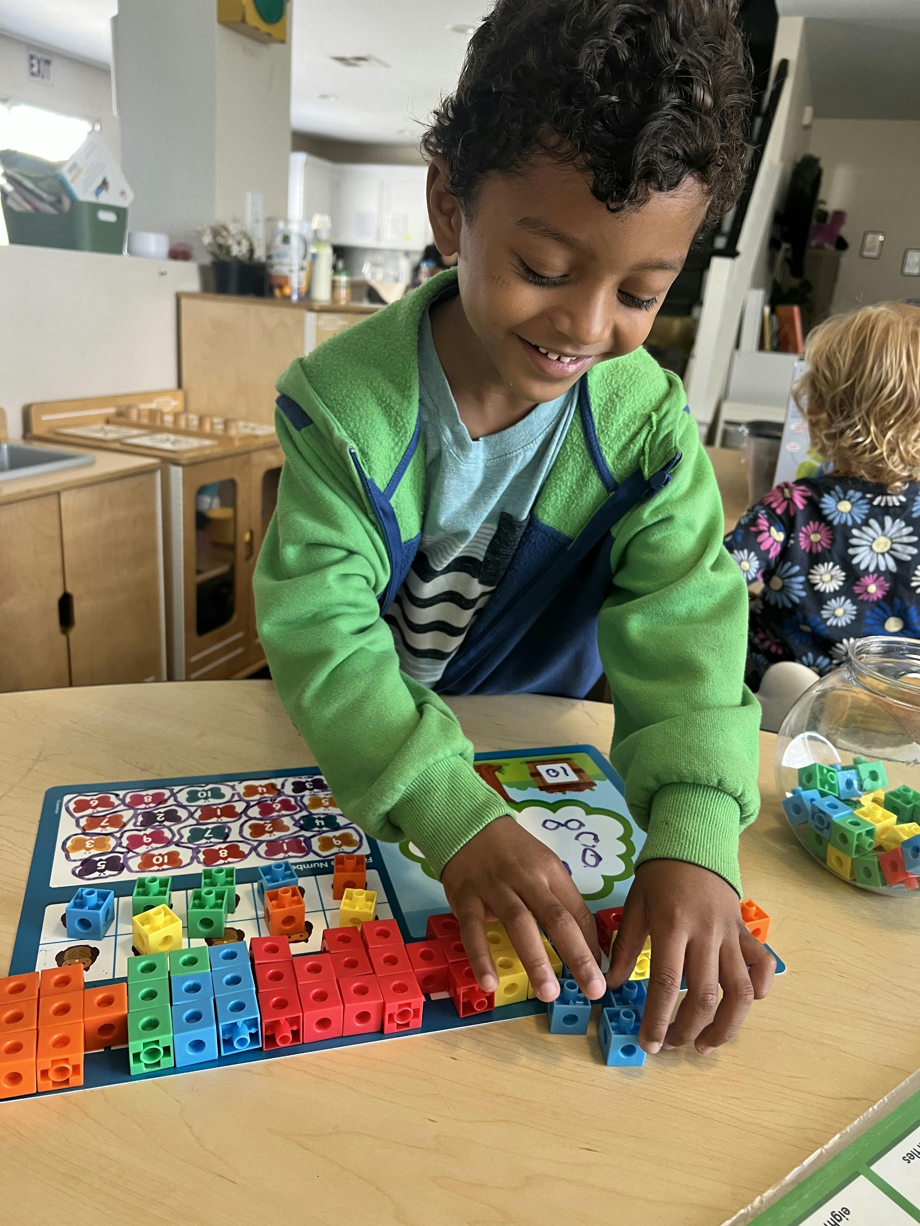 Child playing with colorful interlocking blocks on a table