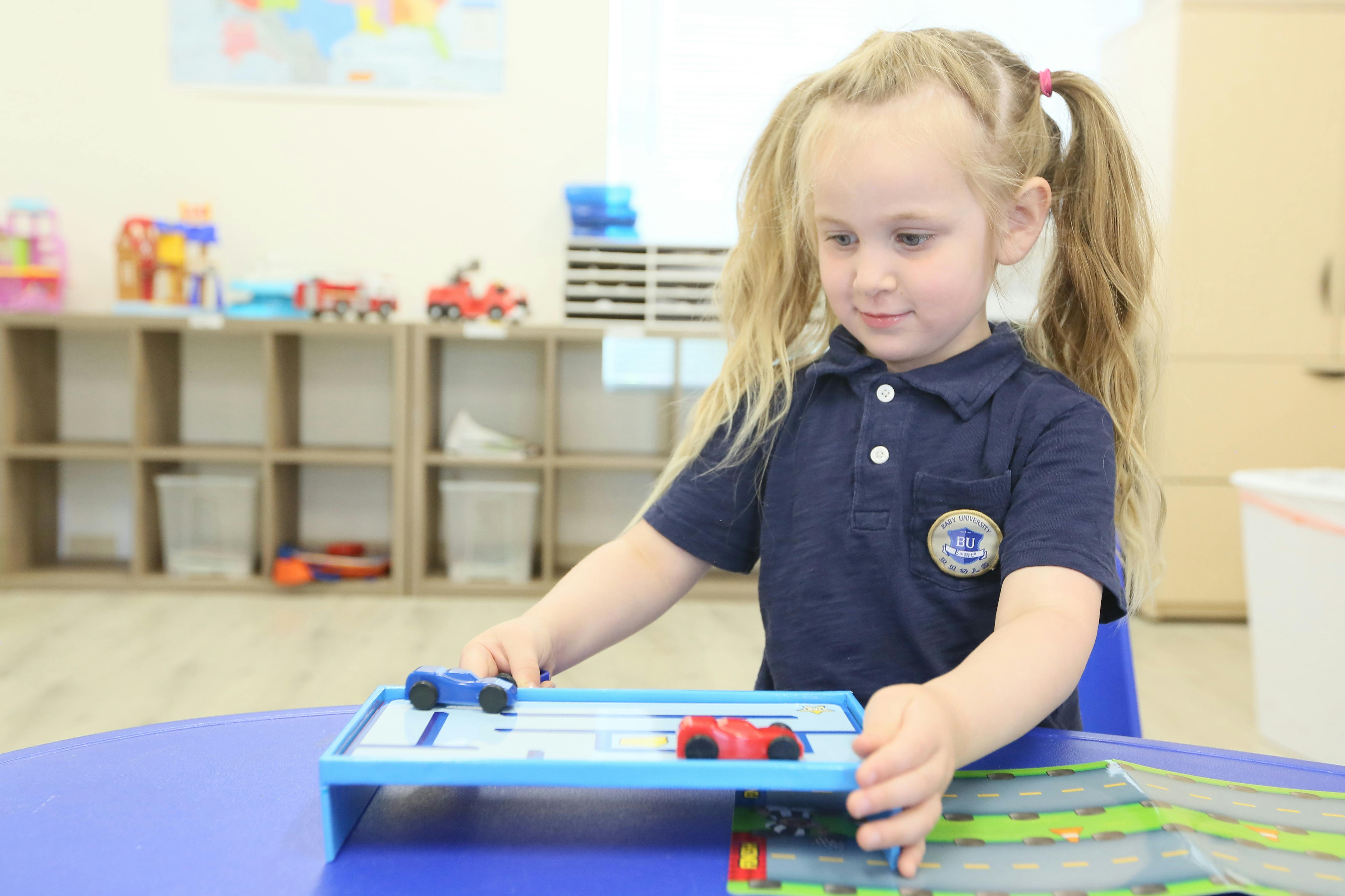 Child playing with toy cars on a track